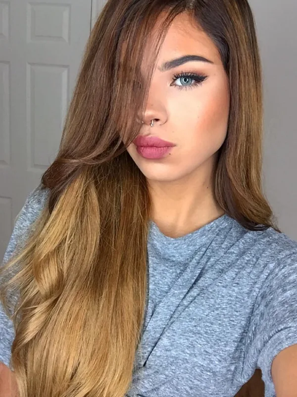 Portrait d'une femme aux cheveux longs bruns et blonds, regardant l'objectif, portant un t-shirt gris et du maquillage.